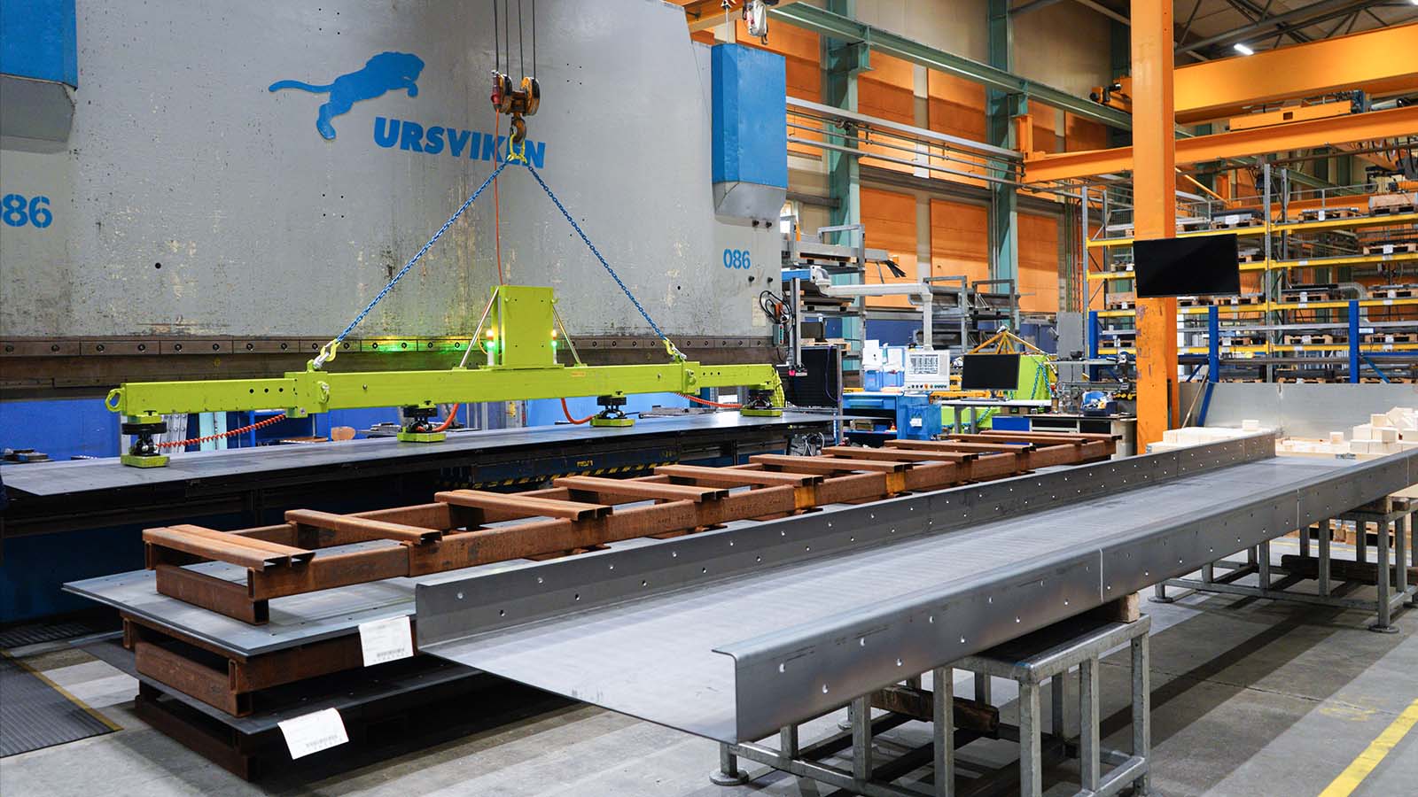 Large steel components positioned in front of a press brake